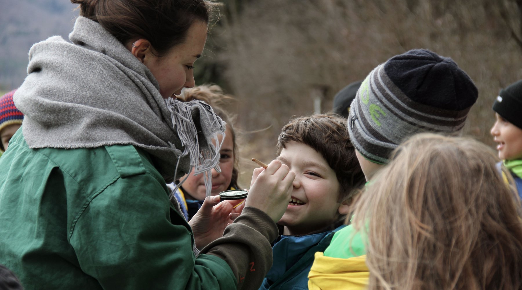 Une responsable scoute maquille un enfant