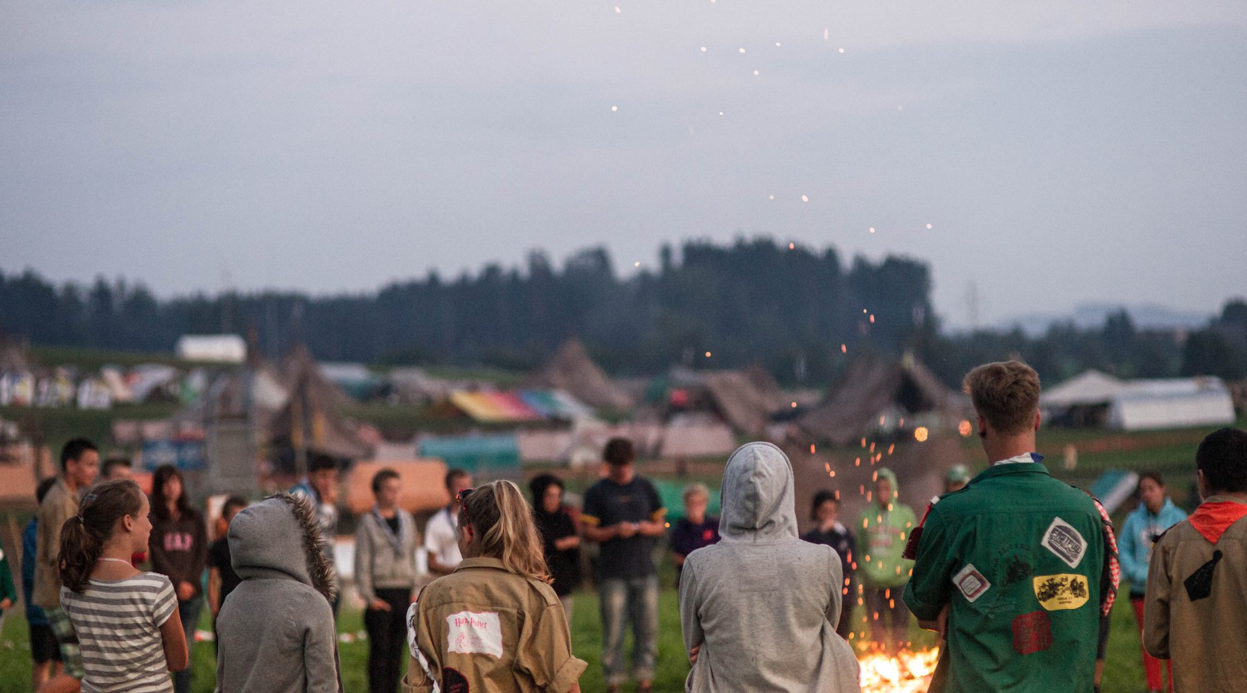 Scouts au feu de camp au coucher du soleil